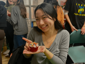 Resident holding up a cupcake she decorated during the event. 