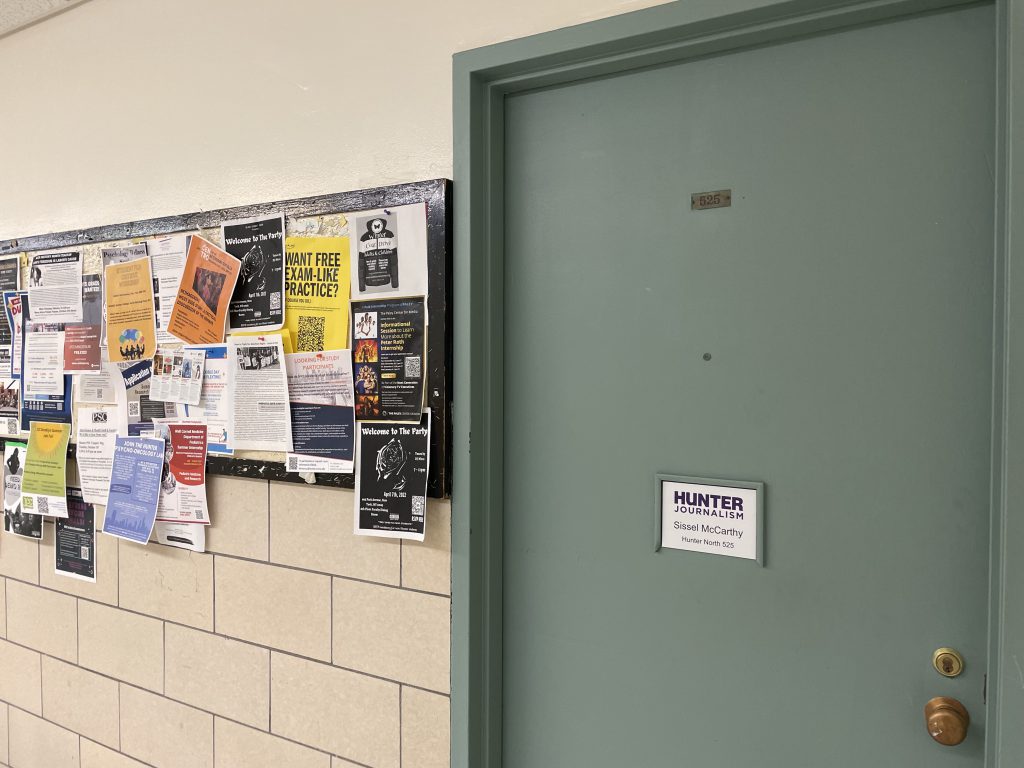 Photo includes Sissel McCarthy's office door next to a bulletin board with flyers and department infomation.