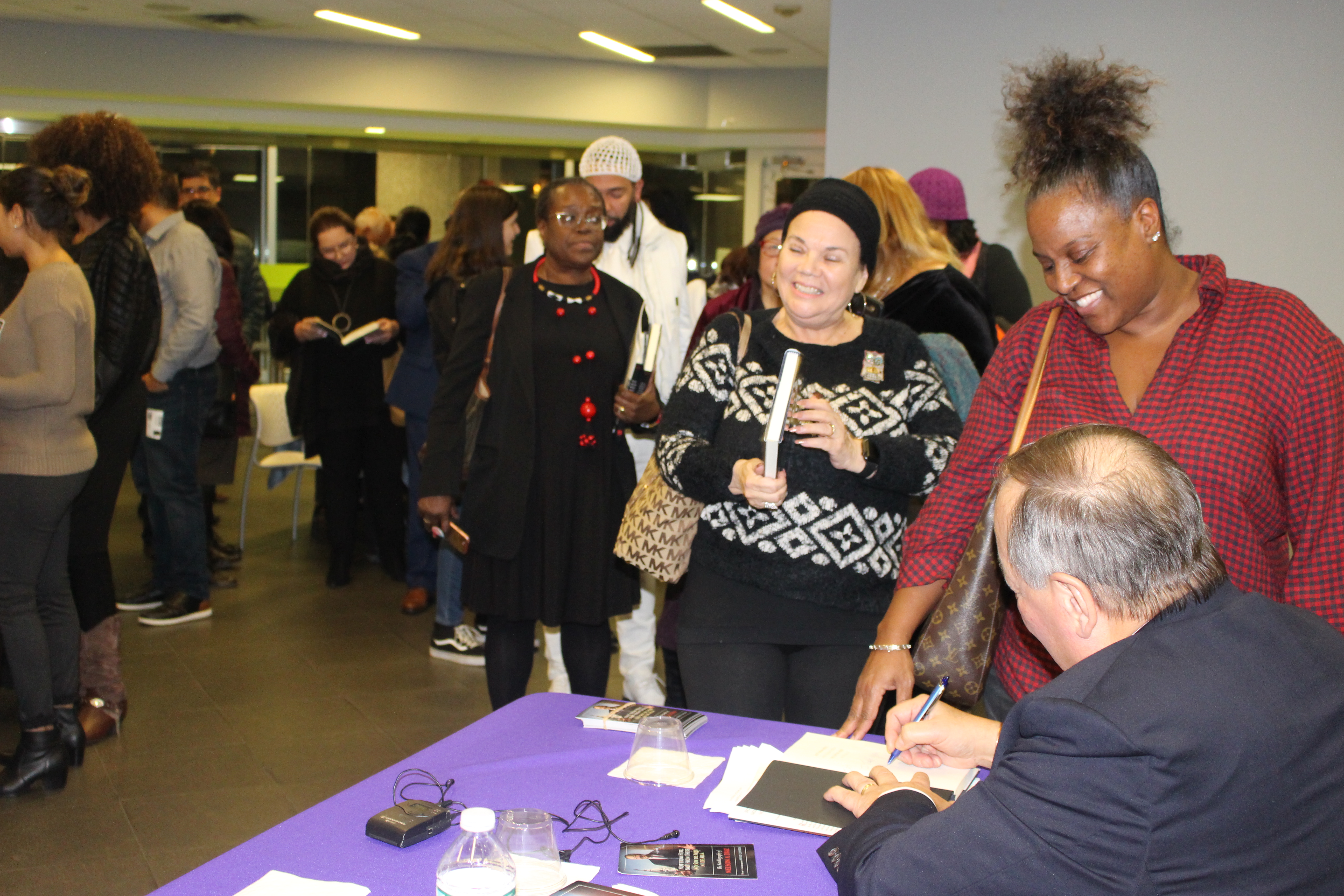 Judge Díaz signs a copy of his new autobiography, "Not from Here, Not from There"