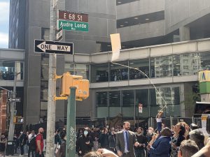 Hunter Staff remove a sleeve to reveal the new Audre Lorde Way streetsign.