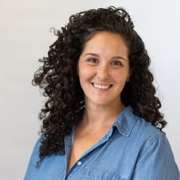 Headshot of white woman with long curly brown hair