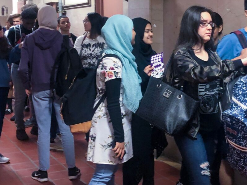 A girl holds a "30 in 30" stamp card as she waits in line for a USG event