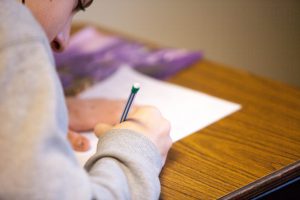 Student writing on piece of paper