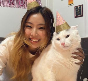 Thulung and her cat Chere pose both wearing birthday hats.