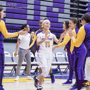 Jade Aponte high-fiving her teammates coming onto the court for her final home game